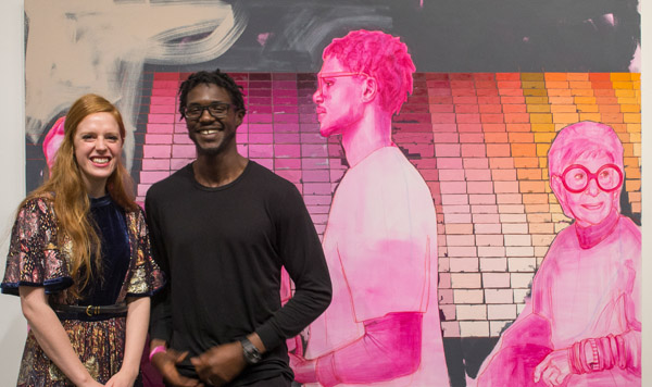 Man and Woman stand in front of Trustman Exhibit piece