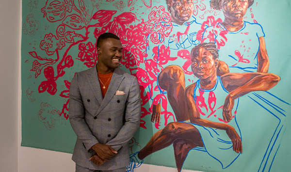 Man stands in front of Trustman Exhibit piece